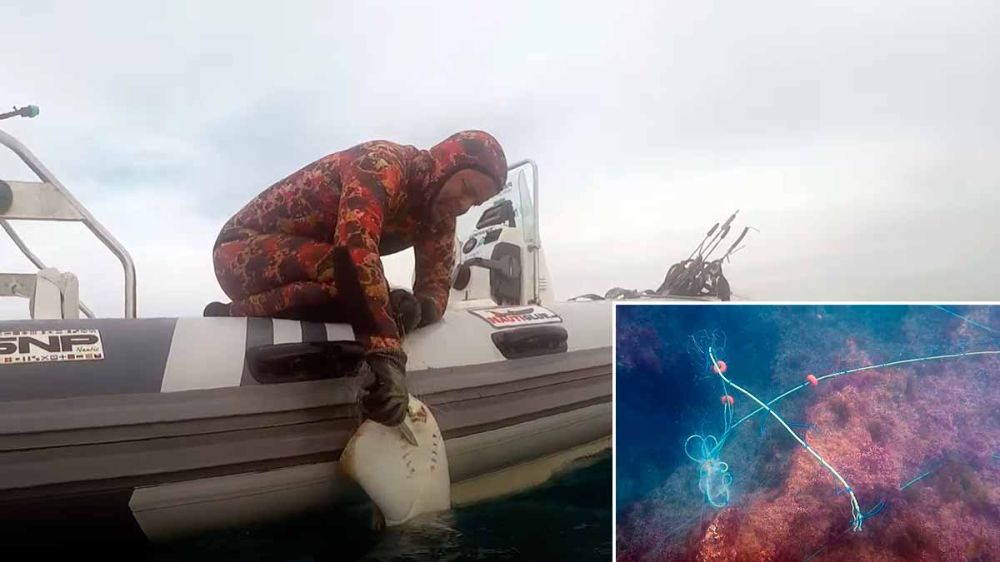 Dos pescadores submarinos cambian el día de pesca por extraer del mar un arte de pesca abandonado